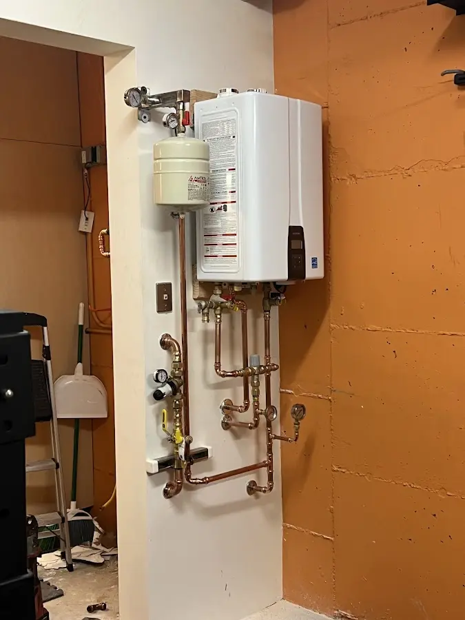 Plumbing technician inspecting water heater connections in Highland Village